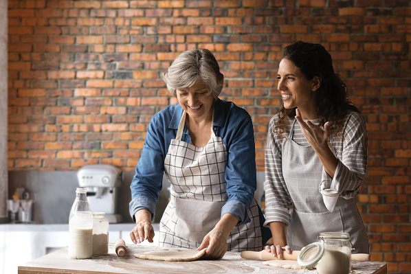 two women smiling and baking